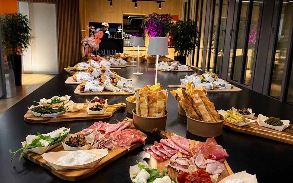 Long table of antipasti boards, cured meats and burrata at a Crosta catering in Berlin